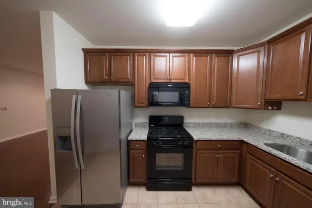 a kitchen with granite countertop stainless steel appliances and cabinets