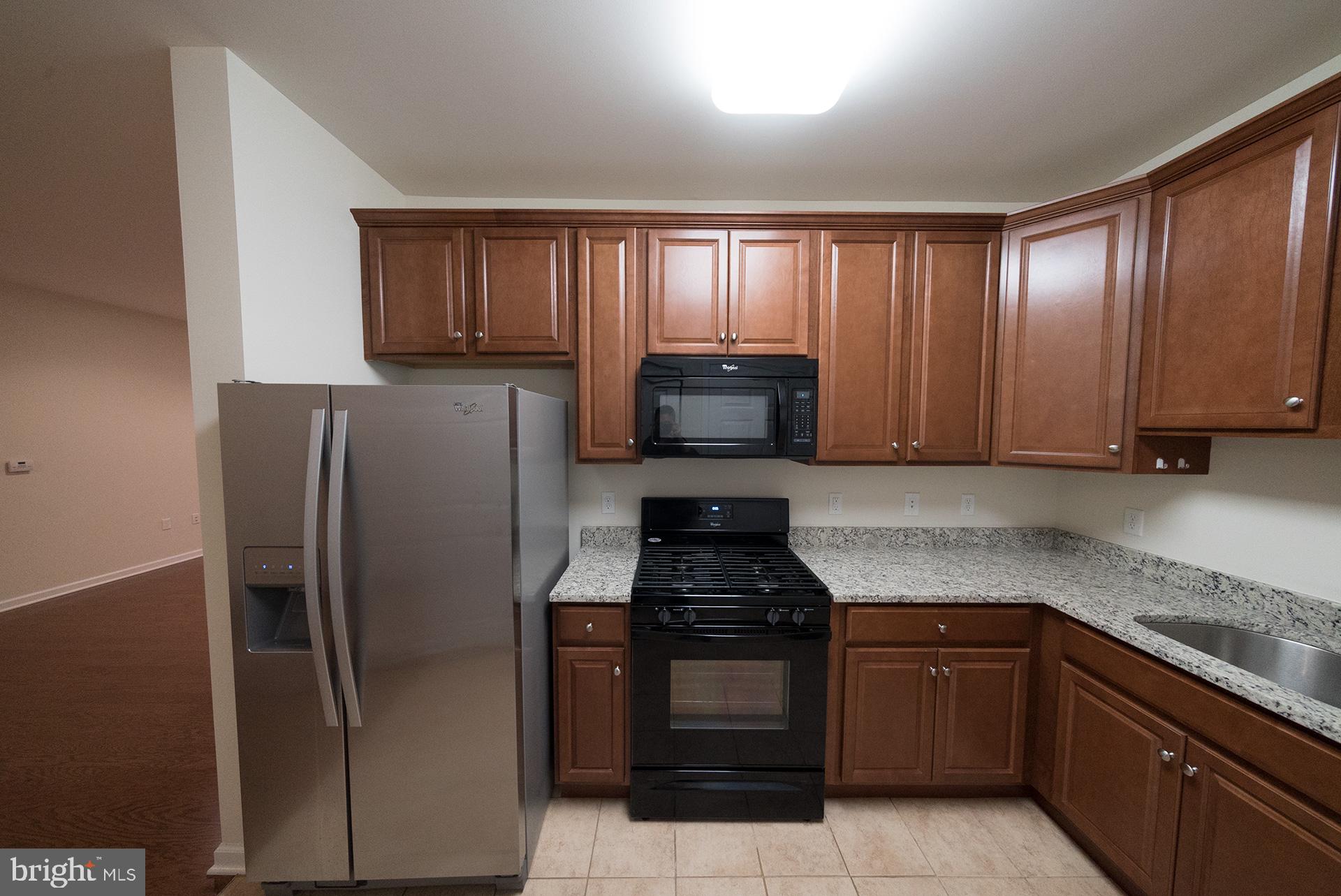 a kitchen with granite countertop stainless steel appliances and cabinets