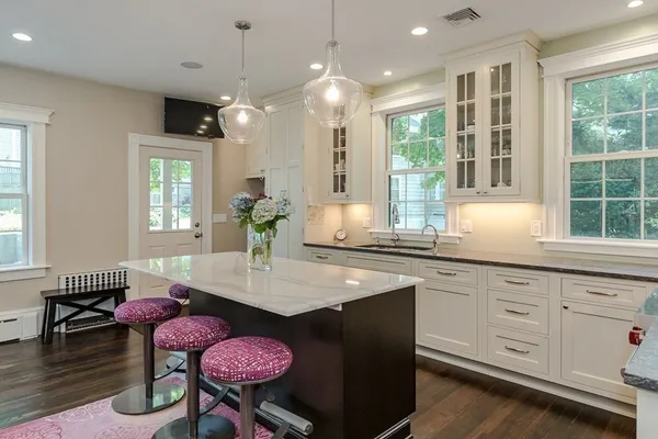a kitchen with granite countertop a stove a dining table and chairs