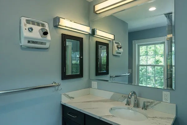 a bathroom with a granite countertop sink and a mirror
