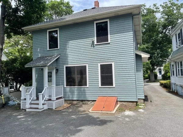 a view of a house with a patio and a yard