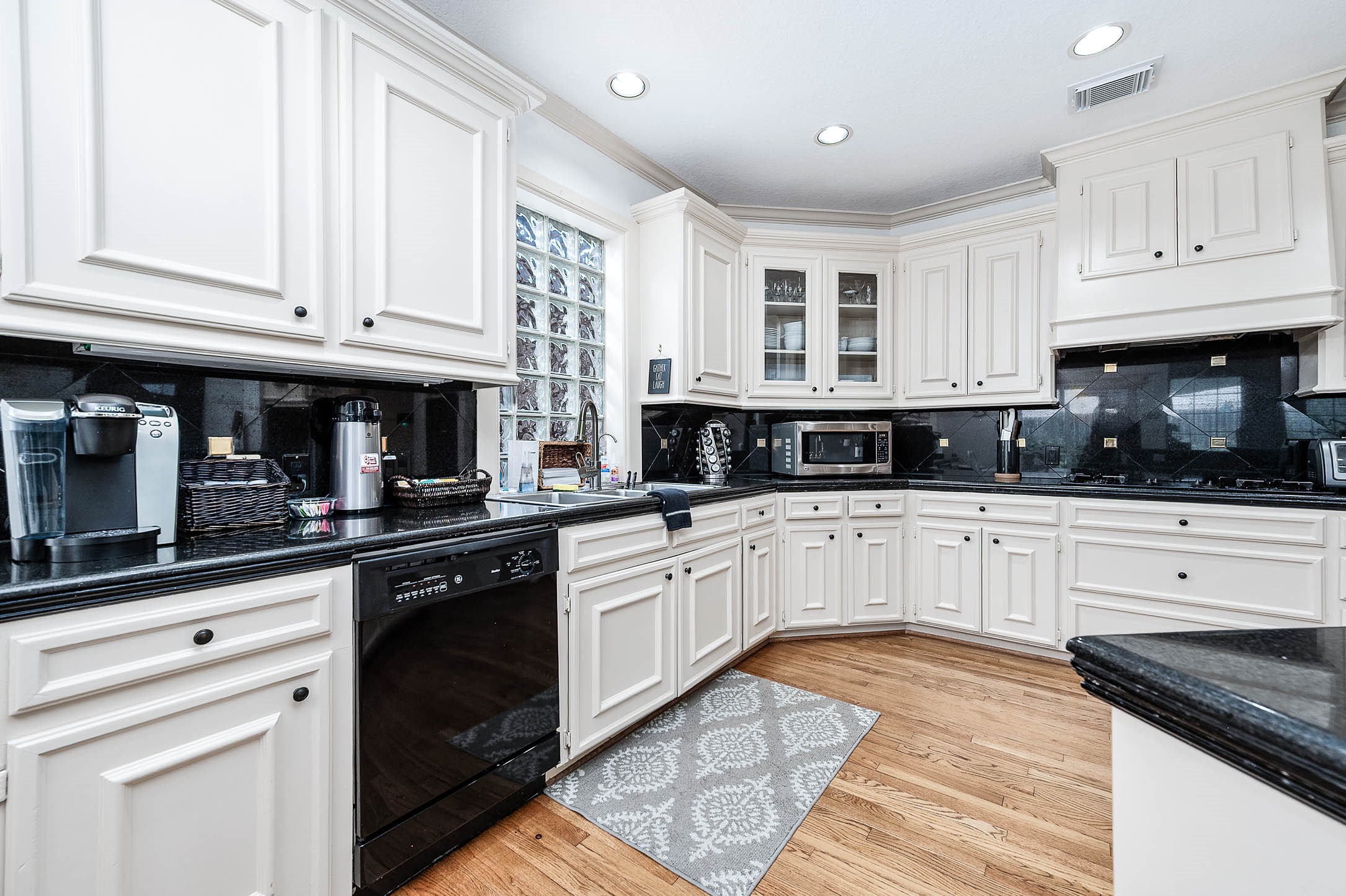 7110 Gary Street Houston, TX 77055 - Photo 14 of 50 a kitchen with stainless steel appliances granite countertop a stove and white cabinets