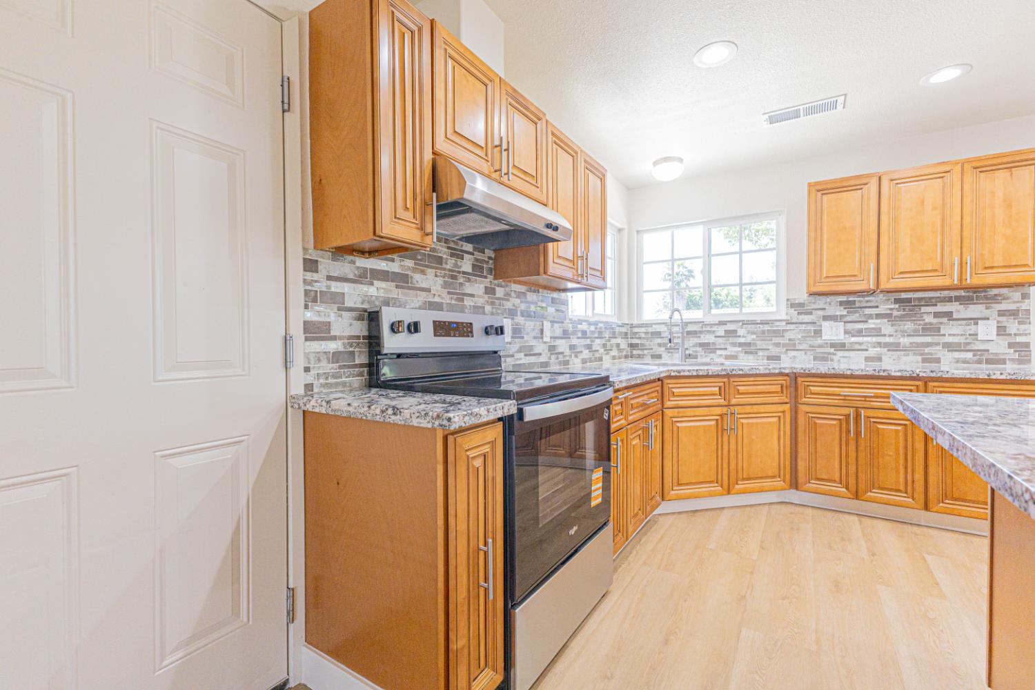 17925 Rodeo Drive Madera, CA 93638 - Photo 9 of 26 a kitchen with stainless steel appliances granite countertop a sink stove and cabinets