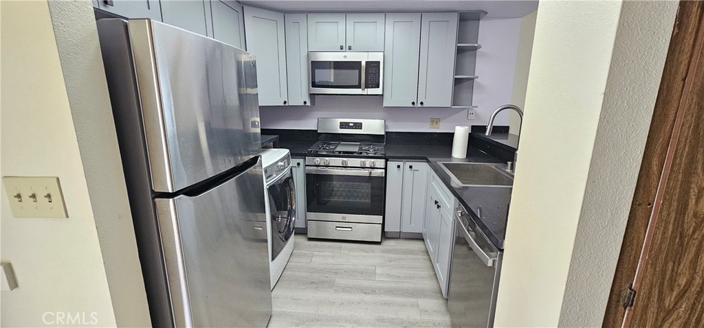 936 Fairway, Unit 23 Grand Terrace, CA 92324 - Photo 3 of 14 a kitchen with stainless steel appliances a refrigerator stove and microwave
