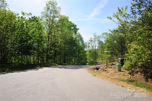 a sign that is sitting in front of a tree