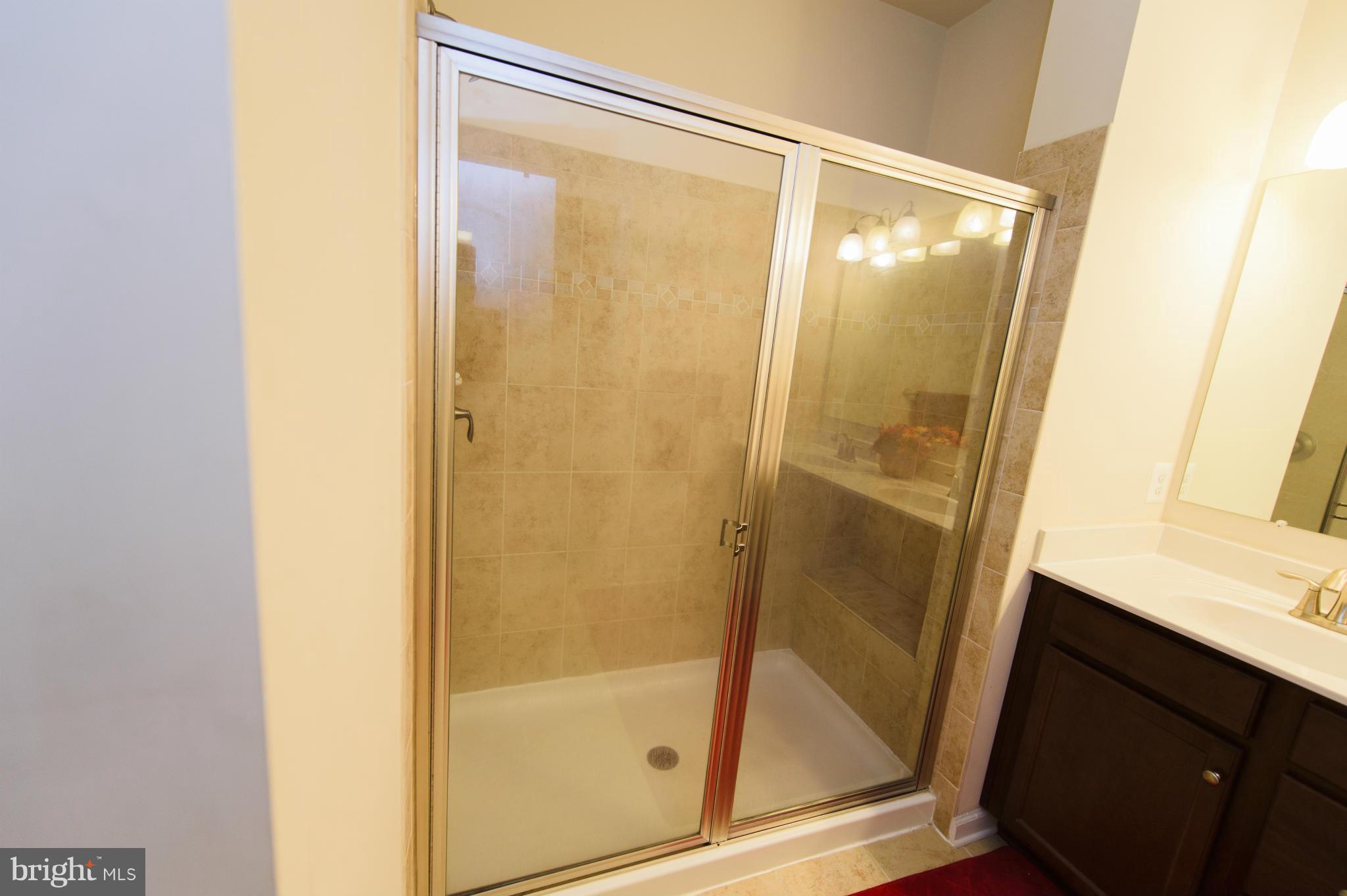 4878 Dane Ridge Circle, Unit 123 Woodbridge, VA 22193 - Photo 17 of 21 a bathroom with a glass door shower and a sink