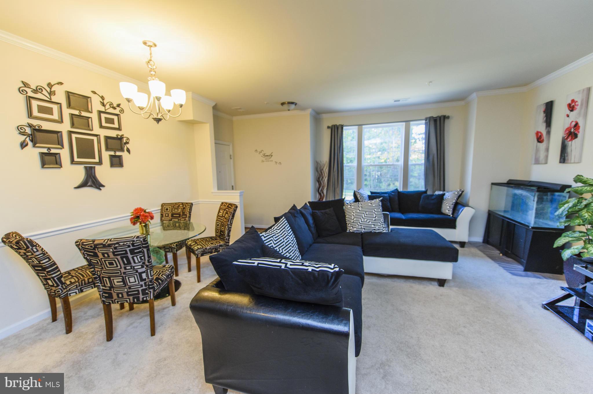 4878 Dane Ridge Circle, Unit 123 Woodbridge, VA 22193 - Photo 3 of 21 a living room with furniture dining table and a fireplace