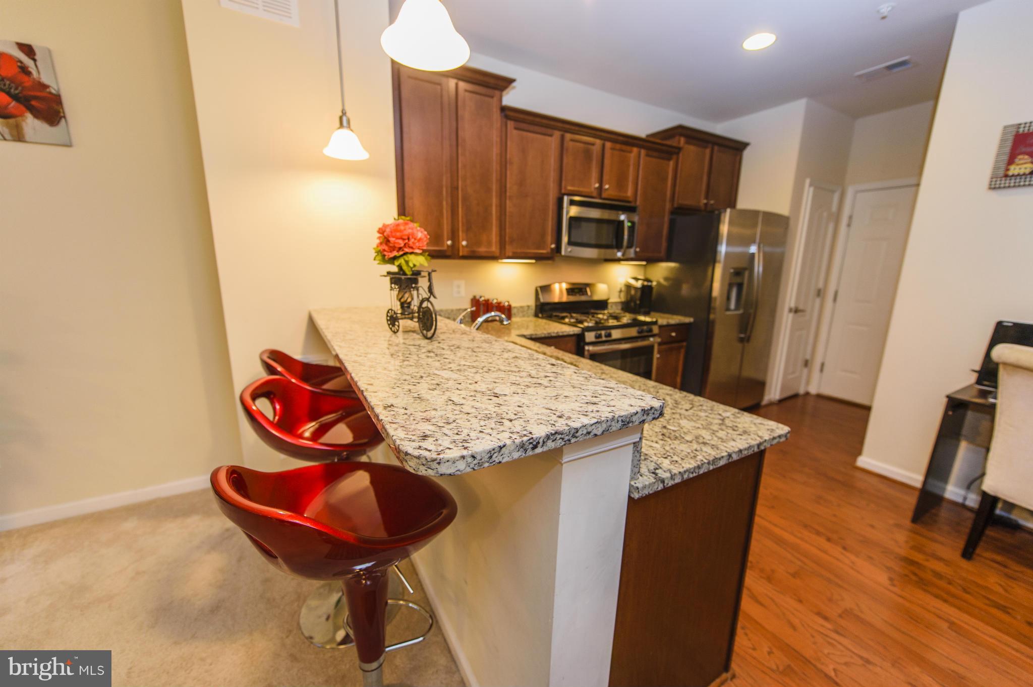 4878 Dane Ridge Circle, Unit 123 Woodbridge, VA 22193 - Photo 5 of 21 a kitchen with stainless steel appliances granite countertop a sink dishwasher stove and refrigerator with wooden floor