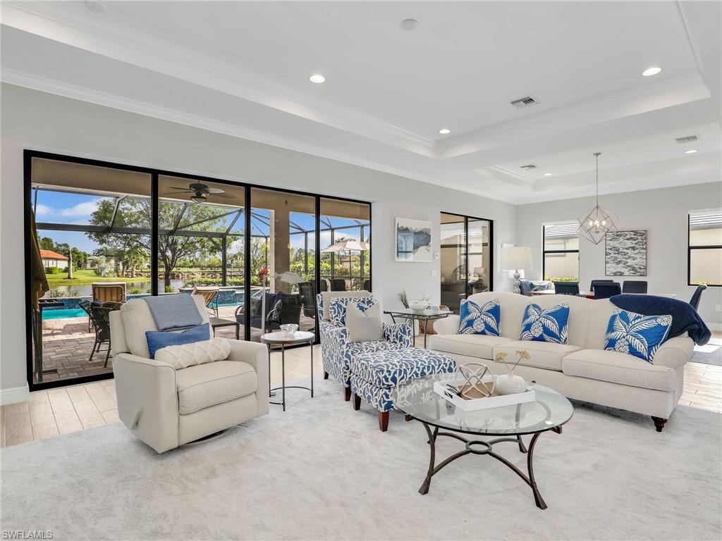 2079 Antigua Lane Naples, FL 34120 - Photo 11 of 44 Living room with a raised ceiling, ornamental molding, a sunroom, recessed lighting, and light wood finished floors