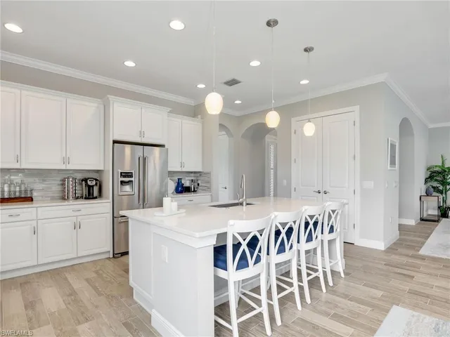 a kitchen with a dining table chairs refrigerator and cabinets