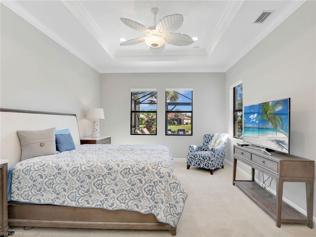 2079 Antigua Lane Naples, FL 34120 - Photo 19 of 44 Bedroom with a tray ceiling, light carpet, ornamental molding, and ceiling fan