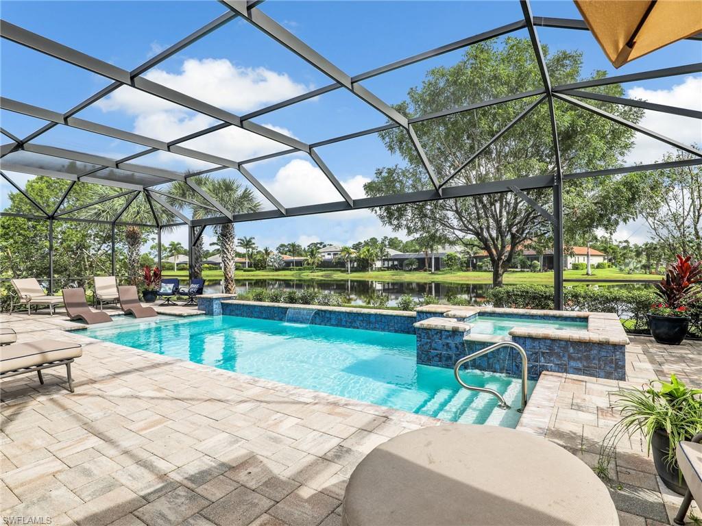 2079 Antigua Lane Naples, FL 34120 - Photo 20 of 44 View of swimming pool featuring a sunroom, a water view, a patio area, a lanai, and a pool with connected hot tub