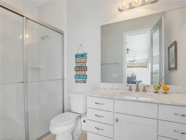 a bathroom with a sink toilet vanity and shower