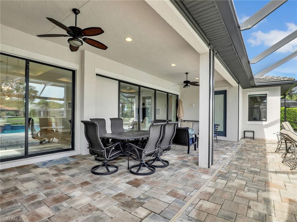 2079 Antigua Lane Naples, FL 34120 - Photo 23 of 44 View of patio with outdoor dining space, ceiling fan, and glass enclosure