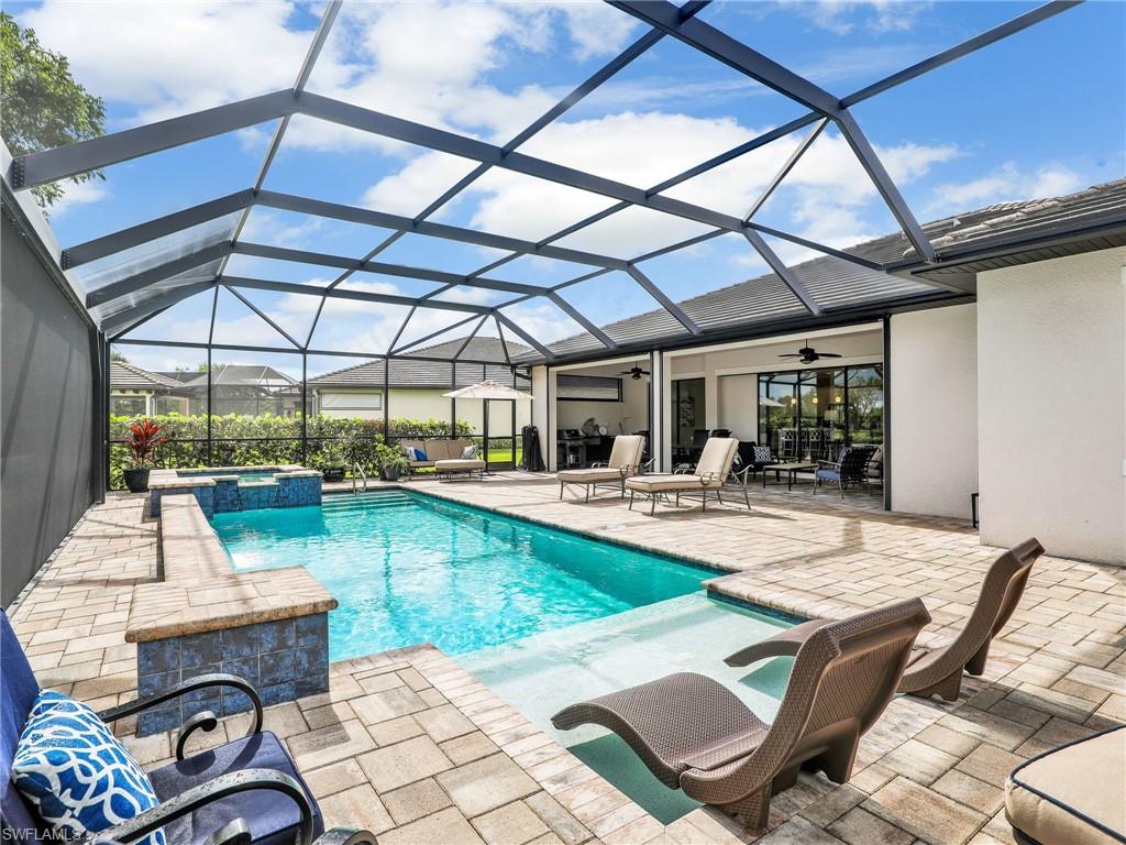 2079 Antigua Lane Naples, FL 34120 - Photo 25 of 44 View of swimming pool with a ceiling fan, a pool with connected hot tub, a sunroom, a patio area, and glass enclosure
