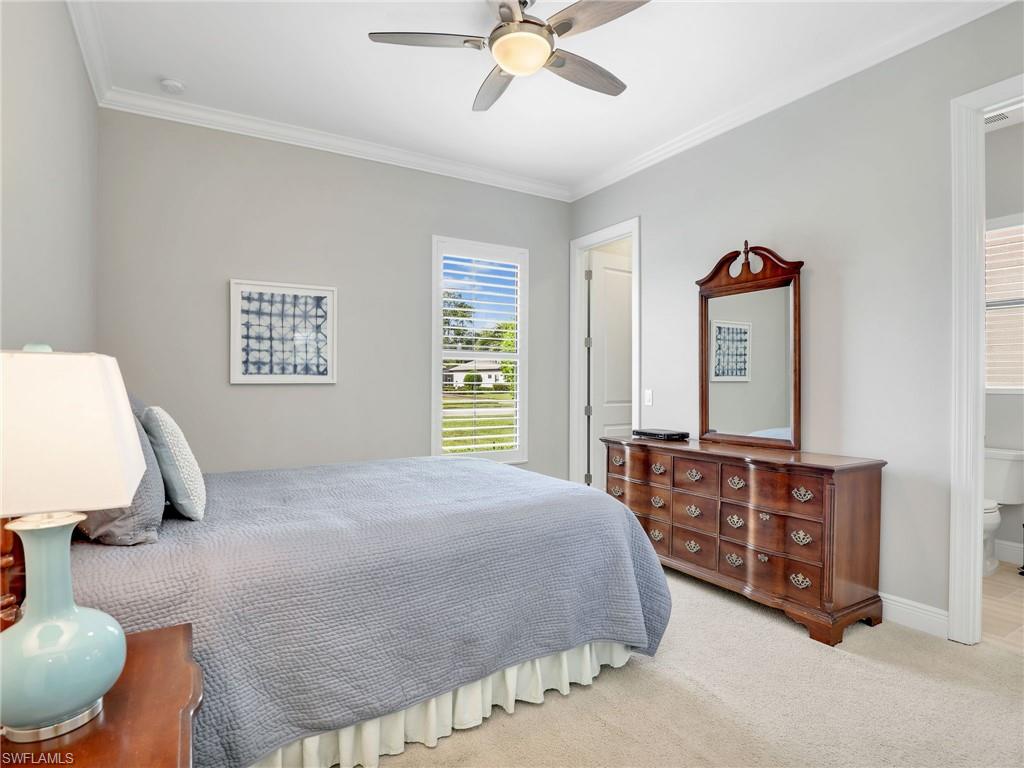 2079 Antigua Lane Naples, FL 34120 - Photo 38 of 44 Bedroom with ornamental molding, light colored carpet, ceiling fan, and ensuite bath