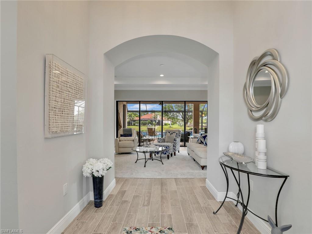 2079 Antigua Lane Naples, FL 34120 - Photo 9 of 44 Hall featuring wood tiled floors, arched walkways, and recessed lighting