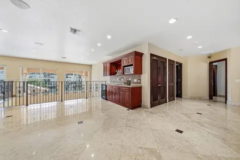 a large kitchen with stainless steel appliances a large counter top a refrigerator and a sink