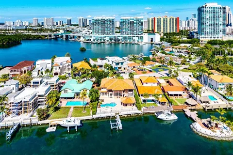 an aerial view of residential houses with outdoor space and lake view
