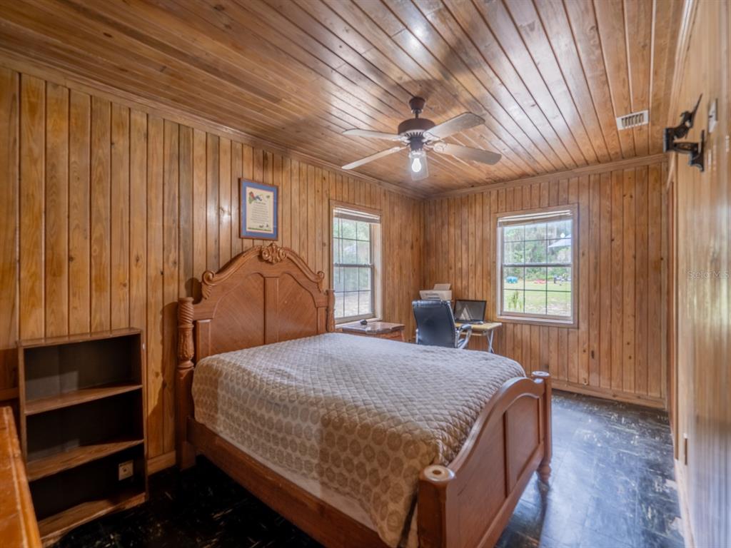 13668 Northeast 226th Avenue Road Fort McCoy, FL 32134 - Photo 13 of 37 a bedroom with a large bed chandelier and a window