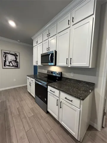 a kitchen with stainless steel appliances granite countertop a stove a sink and a microwave