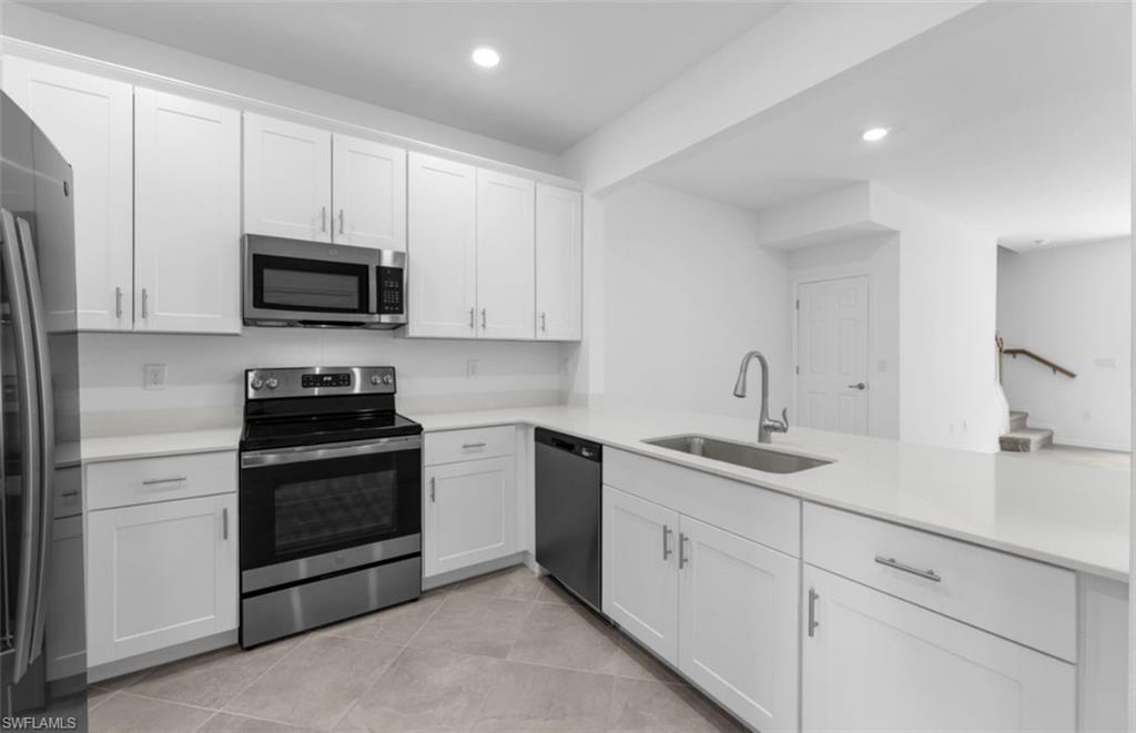 2876 Citrus Street Naples, FL 34120 - Photo 3 of 16 a kitchen with granite countertop white cabinets and stainless steel appliances