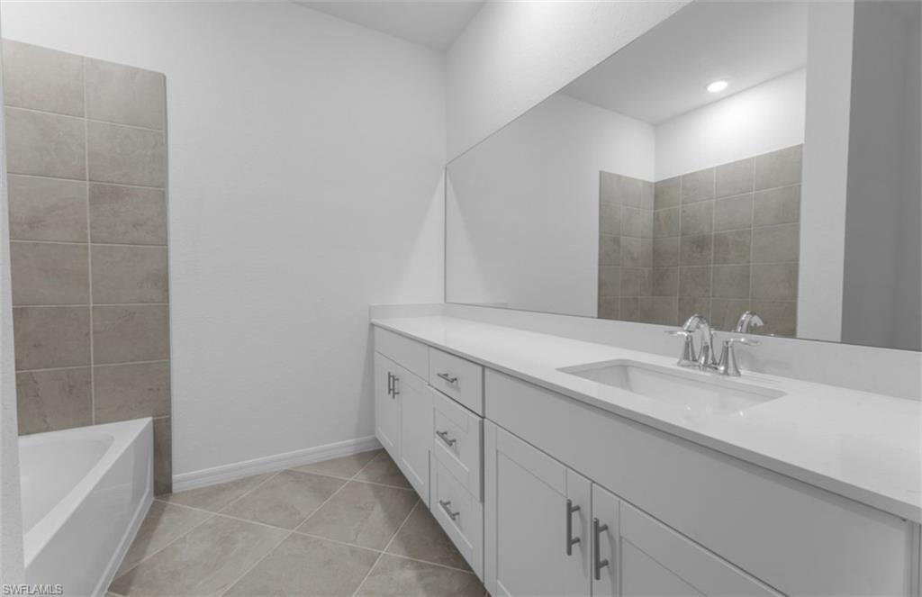 2876 Citrus Street Naples, FL 34120 - Photo 9 of 16 a bathroom with a double vanity sink a mirror and a bathtub