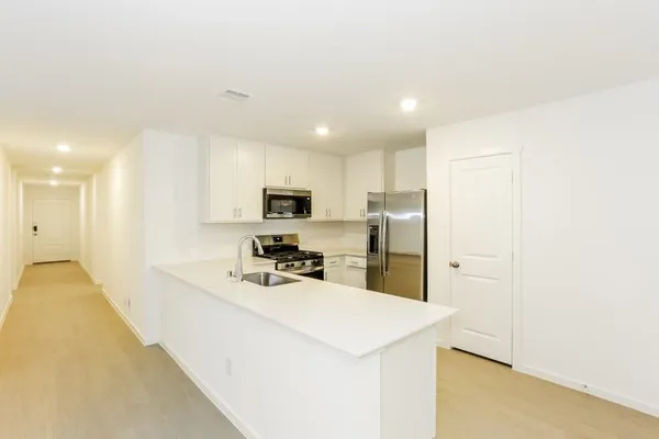 a kitchen with stainless steel appliances a refrigerator sink and microwave
