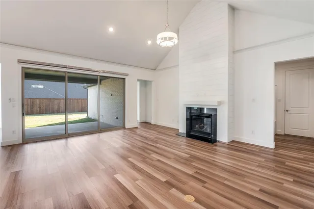 a view of empty room with wooden floor and fireplace