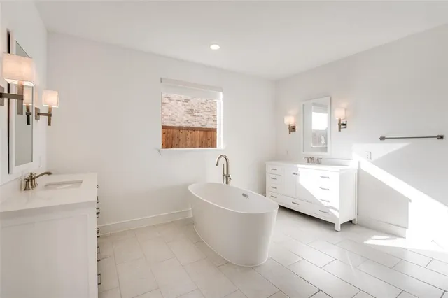 a bathroom with a white tub sink vanity and mirror