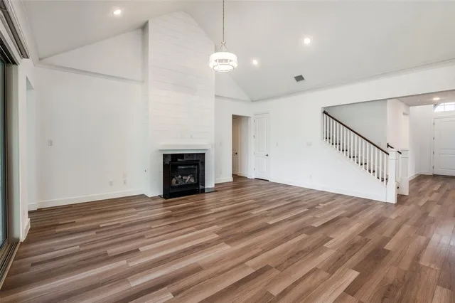 a view of empty room with wooden floor and fireplace