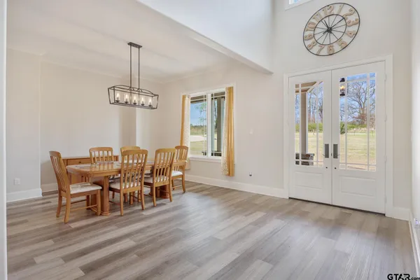 a dining room with furniture a chandelier and wooden floor