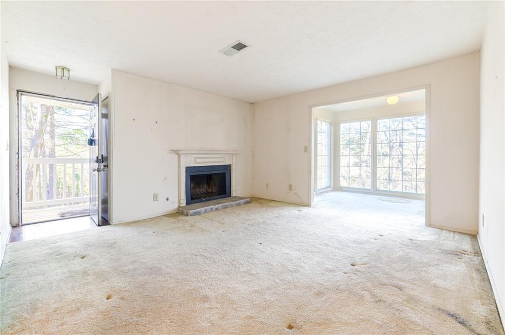 an empty room with windows and fireplace