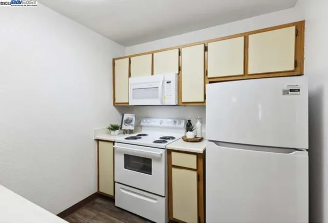 a kitchen with a refrigerator sink stove and cabinets