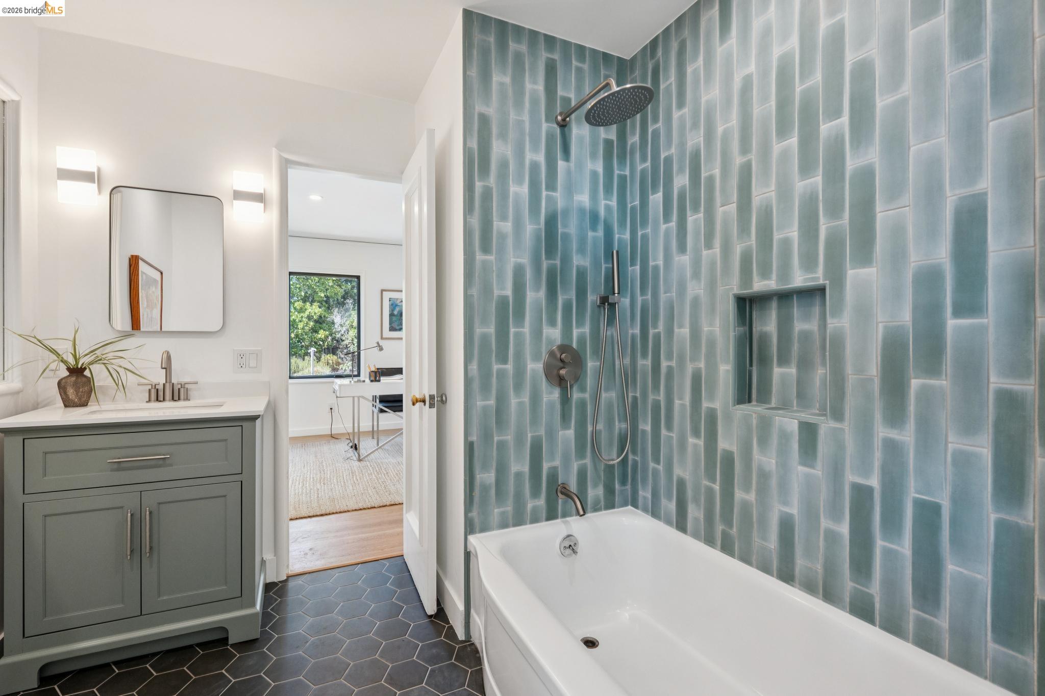38 Highgate Road Kensington, CA 94707 - Photo 32 of 78 Bathroom featuring a white bathtub, blue-toned vertical tile surround, recessed shower niche, and a vanity with a white countertop and rectangular sink