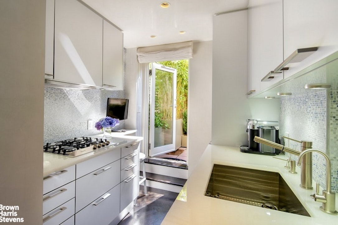 3 East 71st Street, Unit 11/12C Manhattan, NY 10021 - Photo 5 of 14 a kitchen with stainless steel appliances a stove a sink and a refrigerator