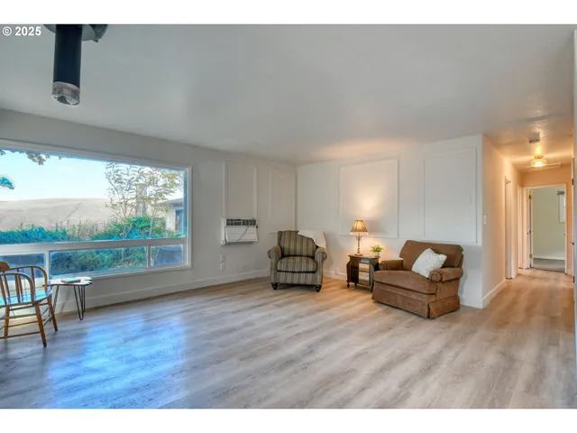 a living room with furniture and a floor to ceiling window