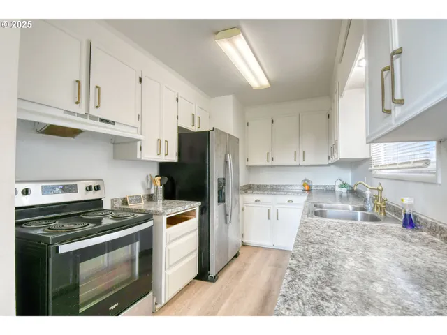 a kitchen with refrigerator a stove a sink dishwasher and cabinets with wooden floor