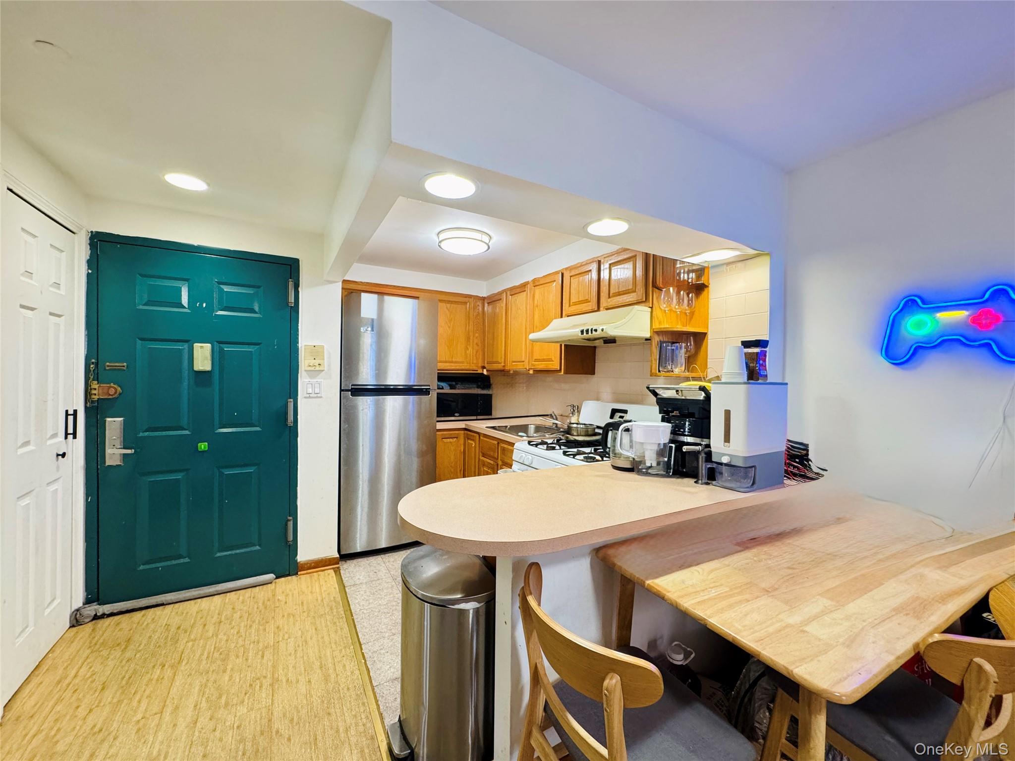 4232 82nd Street, Unit 6B Queens, NY 11373 - Photo 7 of 10 a kitchen with a table chairs and refrigerator
