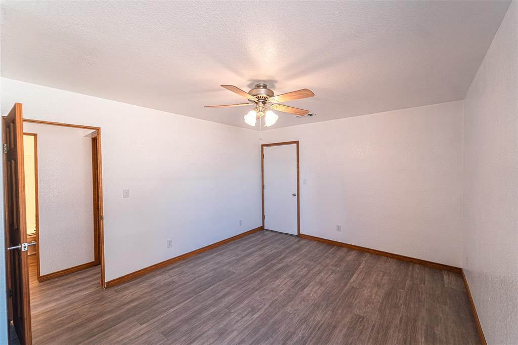 618 Oak Street Clyde, TX 79510 - Photo 17 of 39 an empty room with wooden floor and ceiling fan