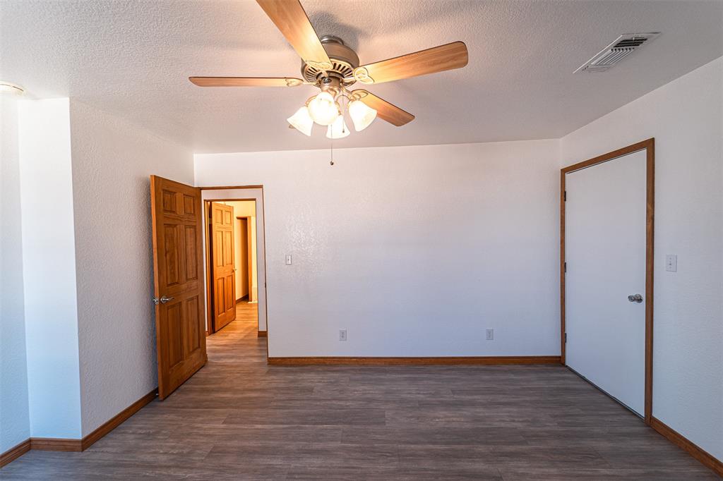 618 Oak Street Clyde, TX 79510 - Photo 18 of 39 an empty room with wooden floor fan and windows