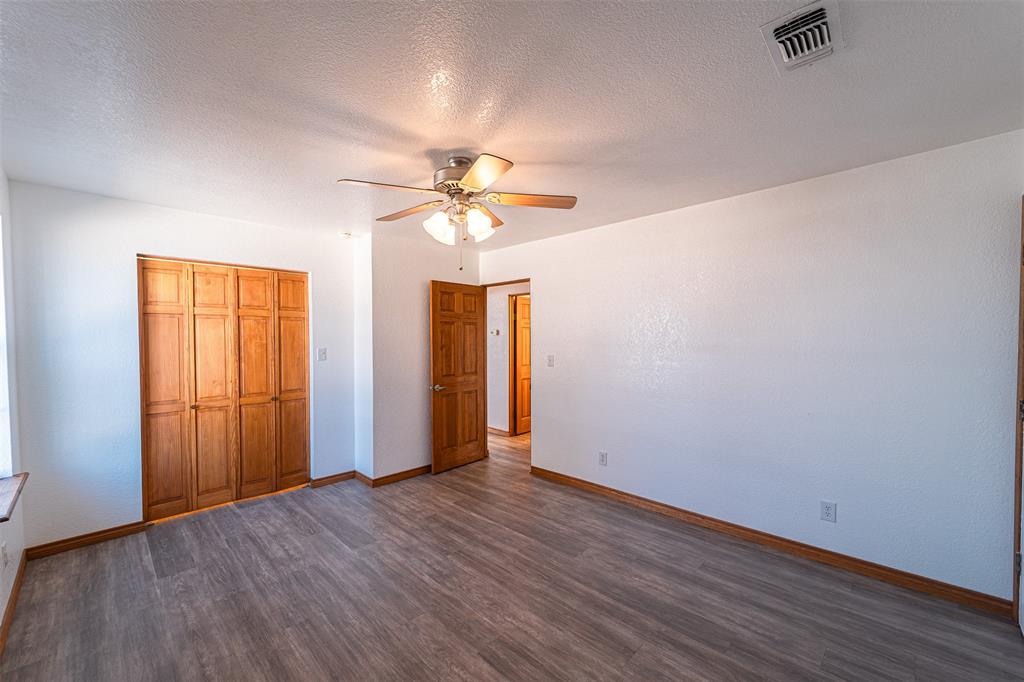 618 Oak Street Clyde, TX 79510 - Photo 19 of 39 an empty room with wooden floor and windows