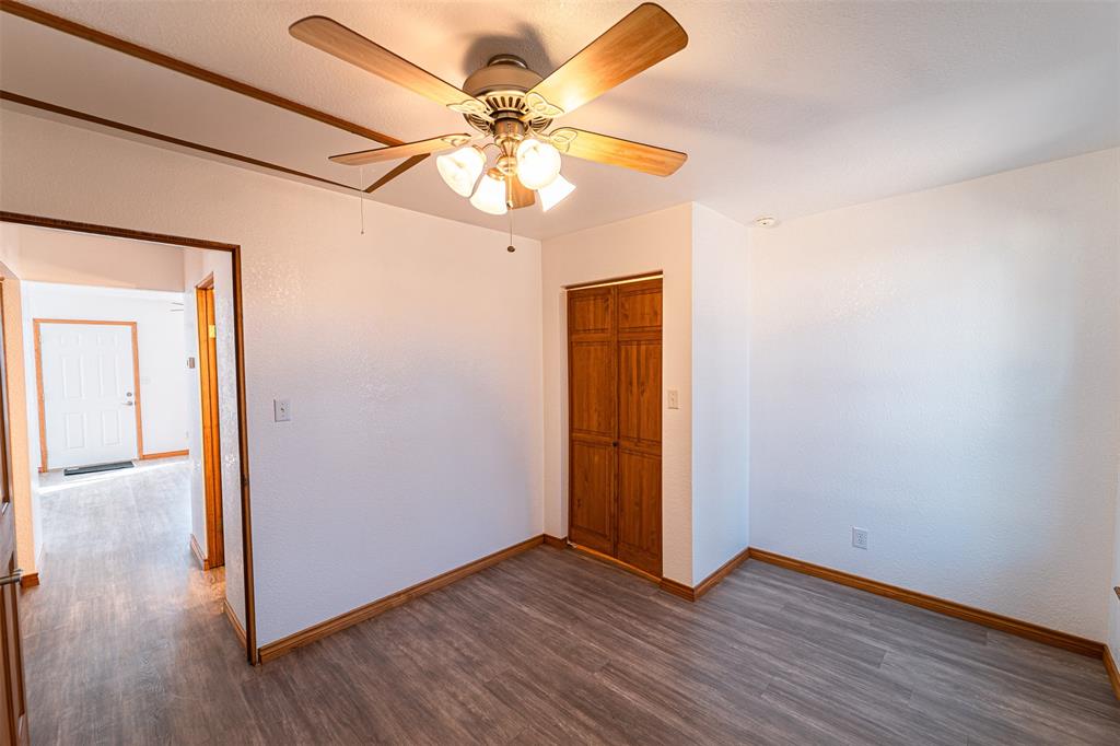 618 Oak Street Clyde, TX 79510 - Photo 24 of 39 an empty room with wooden floor fan and windows