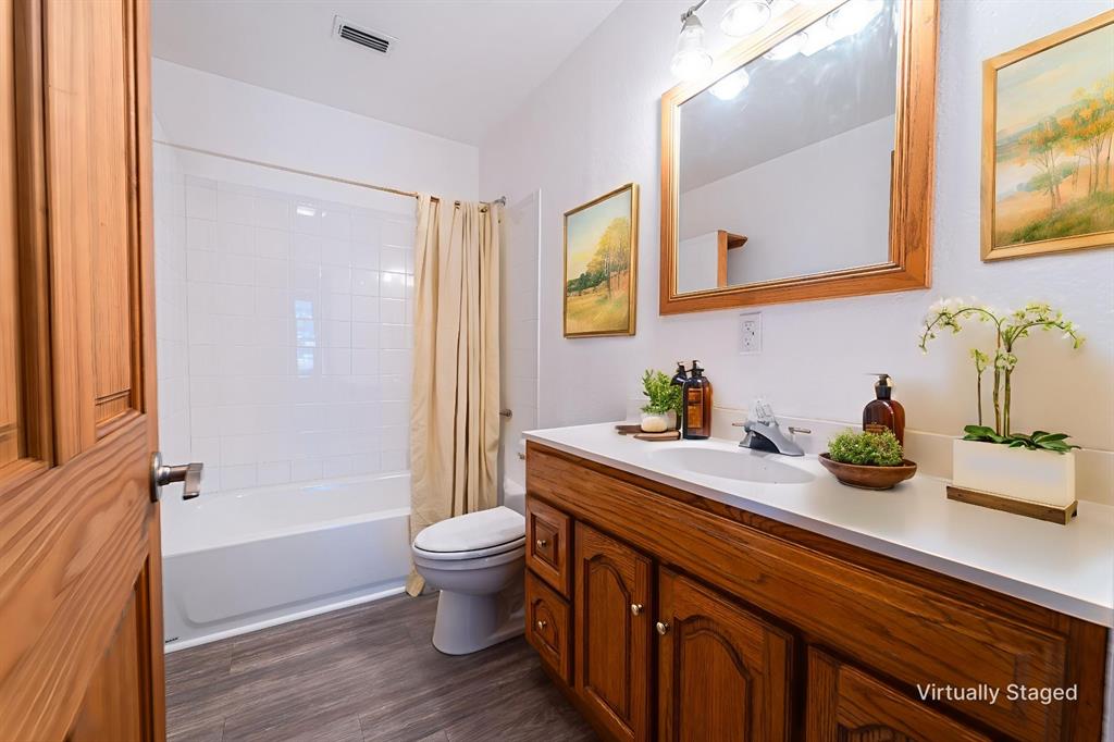 618 Oak Street Clyde, TX 79510 - Photo 26 of 39 a spacious bathroom with a granite countertop sink a toilet a mirror and shower