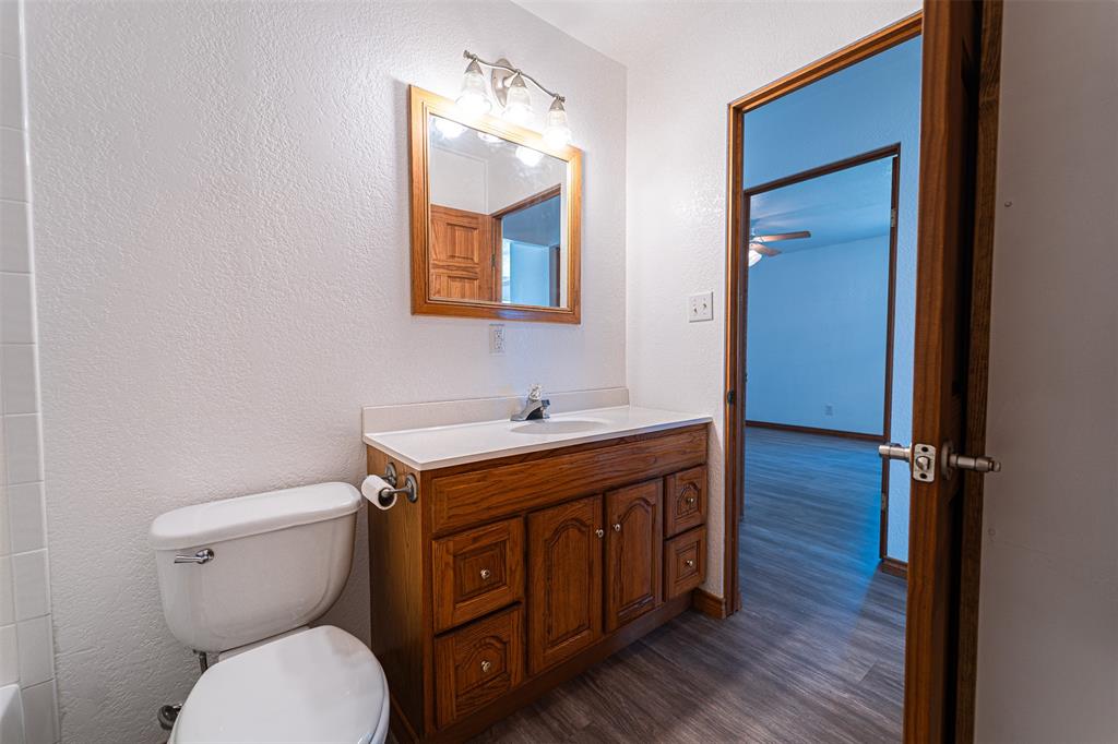 618 Oak Street Clyde, TX 79510 - Photo 27 of 39 a bathroom with a toilet a sink and mirror