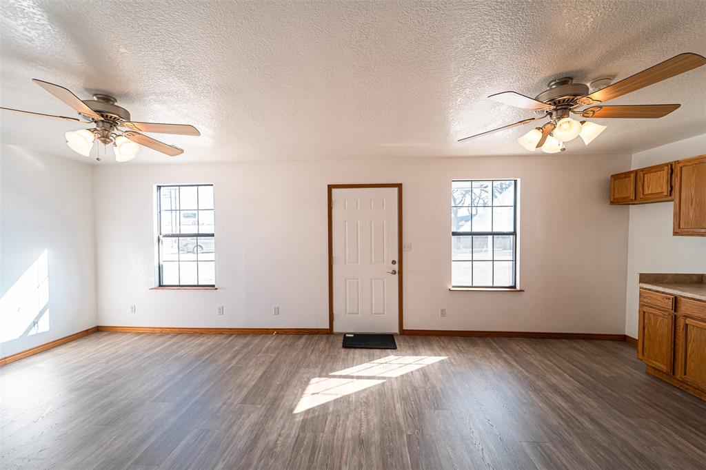 618 Oak Street Clyde, TX 79510 - Photo 5 of 39 a view of an empty room with a window and wooden floor