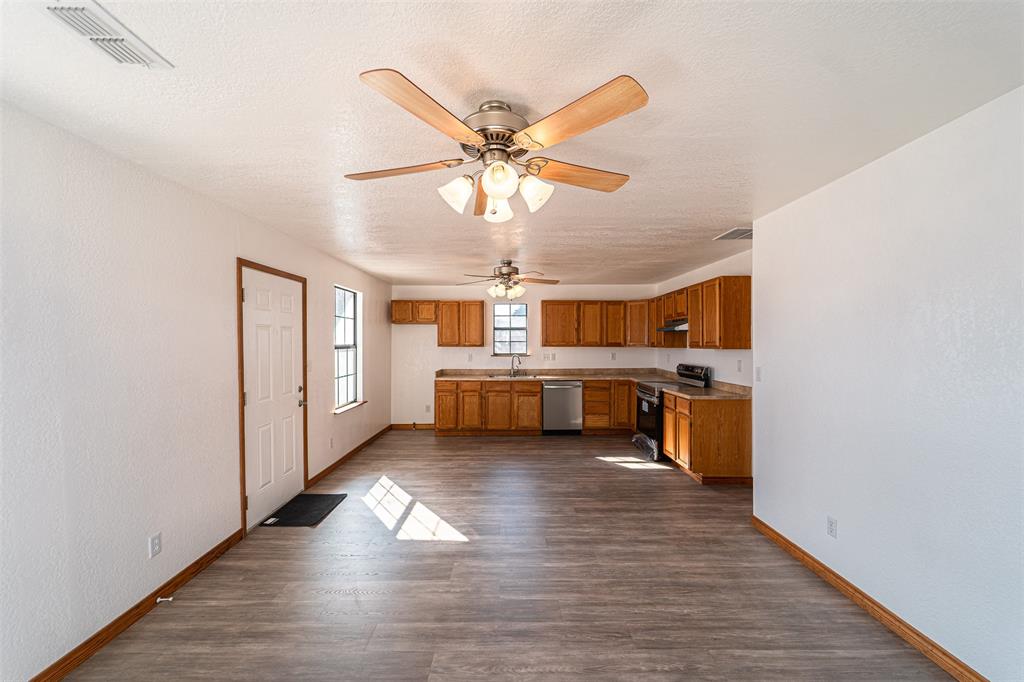 618 Oak Street Clyde, TX 79510 - Photo 7 of 39 a open kitchen with stainless steel appliances granite countertop a dishwasher cabinets and couches with wooden floor