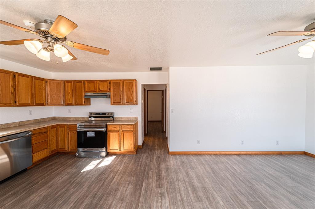 618 Oak Street Clyde, TX 79510 - Photo 9 of 39 a kitchen with stainless steel appliances granite countertop a sink cabinets and wooden floor