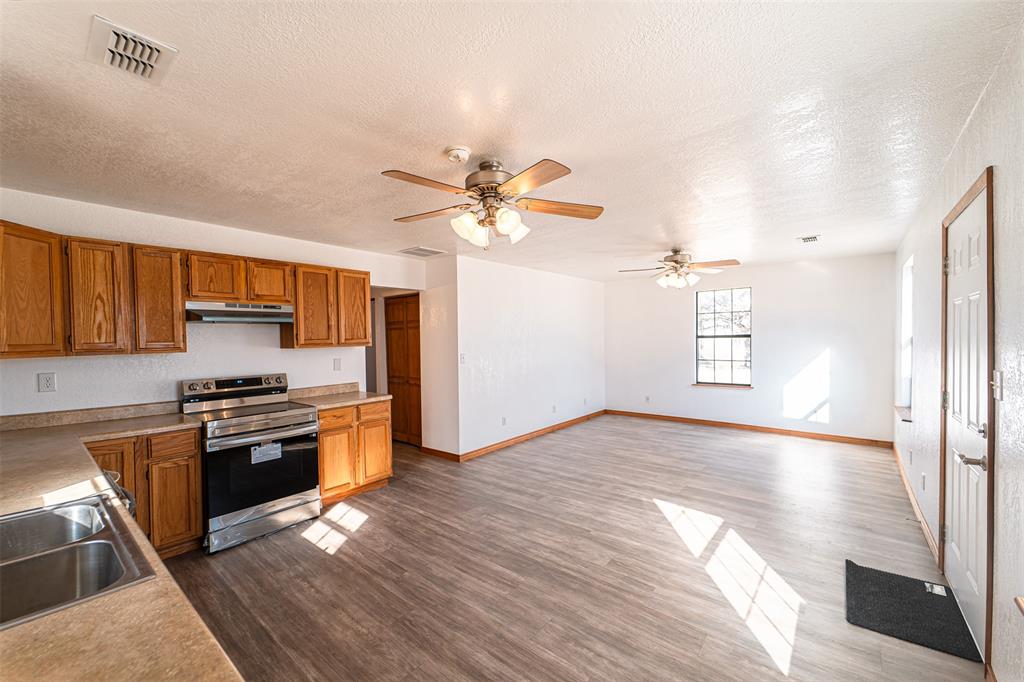 618 Oak Street Clyde, TX 79510 - Photo 10 of 39 a kitchen with stainless steel appliances granite countertop a stove cabinets and wooden floor