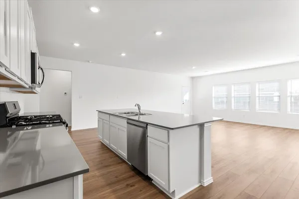 a kitchen with granite countertop a sink and a stove top oven